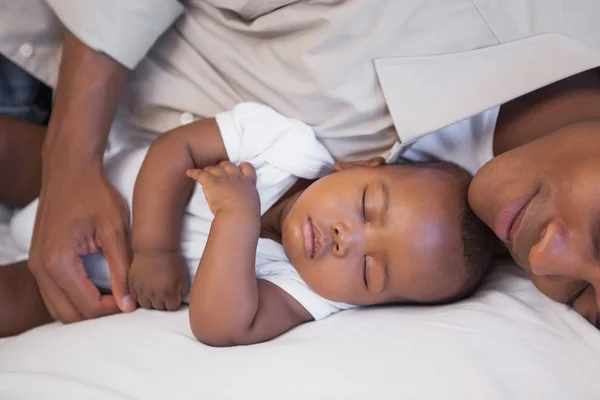 Father napping with baby son on couch Royalty Free Stock Images