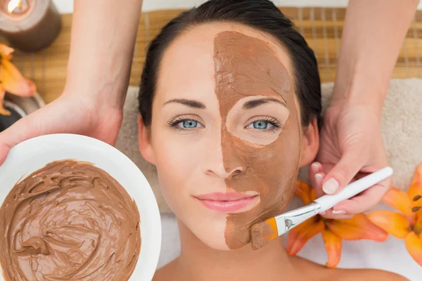 Peaceful brunette getting a mud facial applied — Stock Photo, Image