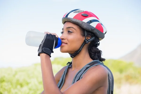 Fit woman going for bike ride drinking water — Stock Photo, Image