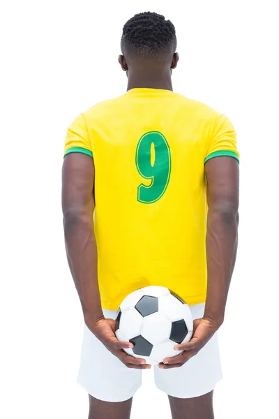 Jogador de futebol em amarelo de pé com a bola — Fotografia de Stock