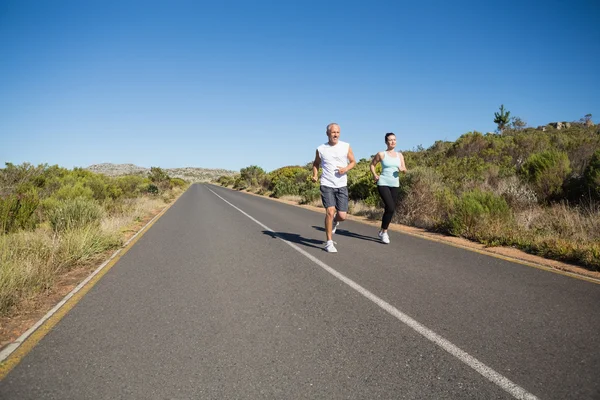 Ajuste pareja corriendo en el camino abierto juntos — Foto de Stock