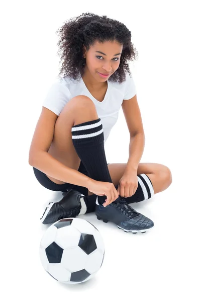 Pretty football player in white tying her shoelace — Stock Photo, Image