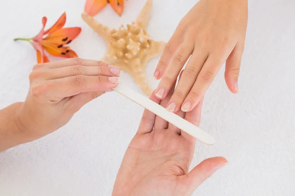 Beautician filing female client's nails at spa beauty salon — Stock Photo, Image