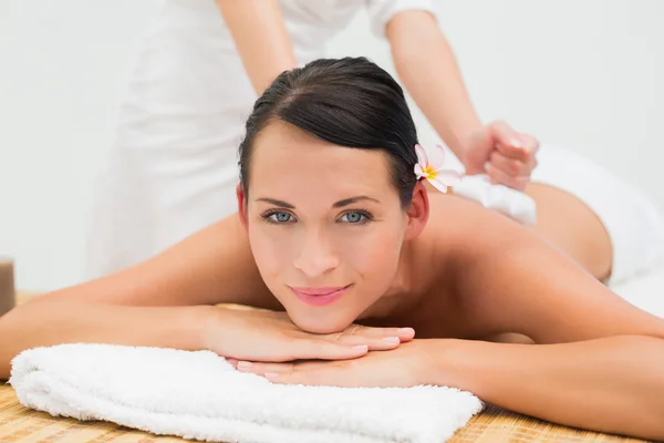 Friedliche Brünette genießt eine Kräuterkompresse Massage — Stockfoto