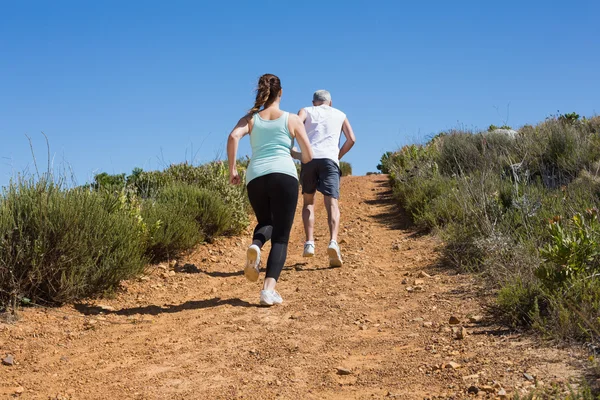 Fit couple running up mountain trail — Stock Photo, Image