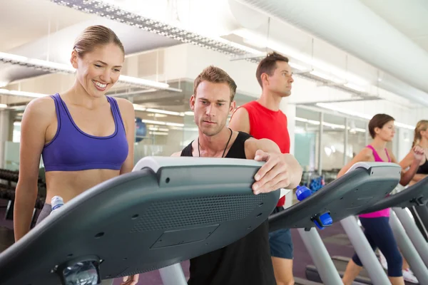 Trainer im Gespräch mit seinem Klienten auf dem Laufband — Stockfoto