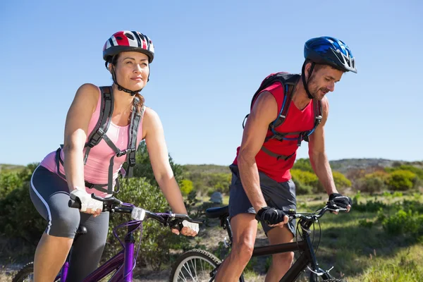 Ativo casal de ciclismo no campo — Fotografia de Stock
