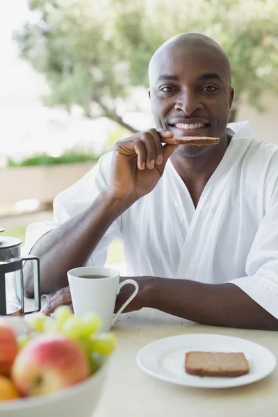 Knappe man in badjas ontbijten buiten — Stockfoto