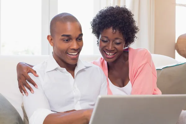 Nettes Paar entspannt auf Couch mit Laptop — Stockfoto