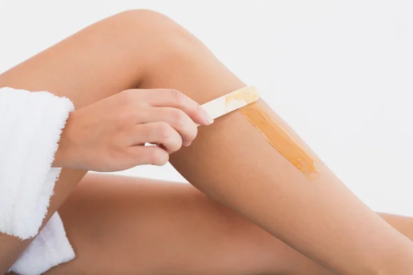 Side view of female applying hot wax on leg — Stock Photo, Image