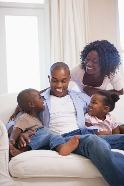 Happy family sitting on couch together — Stock Photo, Image