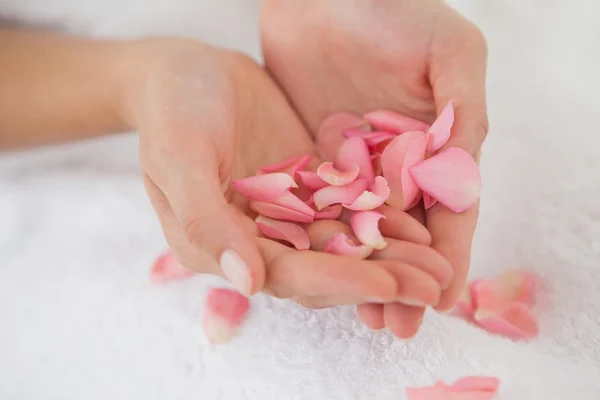 Vrouw met roze rozenblaadjes — Stockfoto