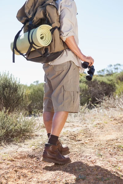 Hiker holding his binoculars on country trail — Stock Photo, Image