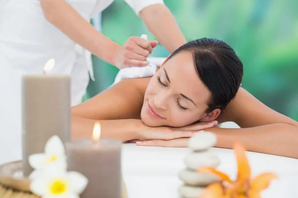 Brünette genießt Kräuterkompresse Massage — Stockfoto