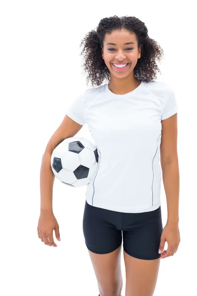 Bastante fanático del fútbol en blanco sosteniendo la pelota sonriendo a la cámara — Foto de Stock