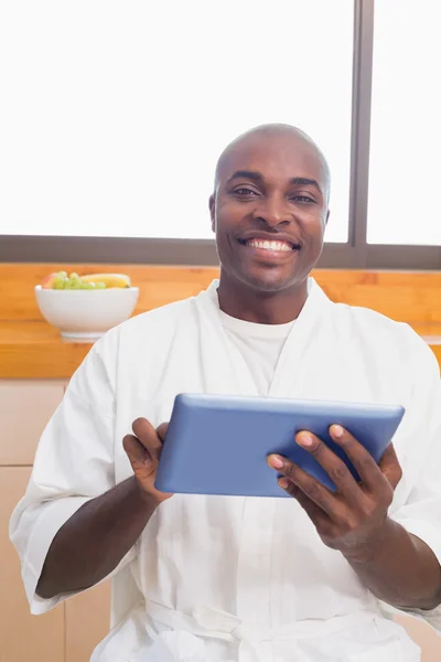 Gelukkig man in badjas gebruiken, tablet pc — Stockfoto