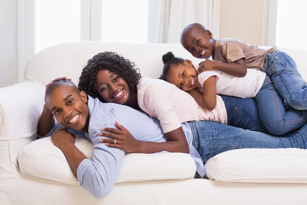 Happy family posing on the couch together — Stock Photo, Image