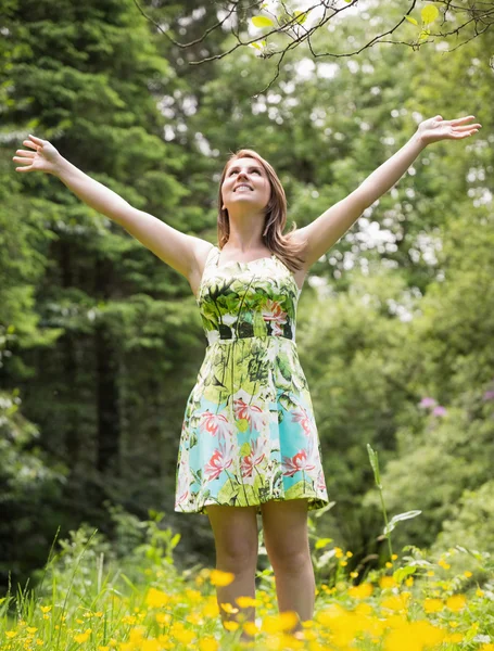 Femme avec les bras tendus dans le champ contre les arbres — Photo