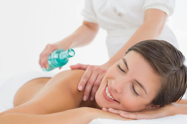 Atractiva mujer recibiendo aceite de masaje en su espalda — Foto de Stock