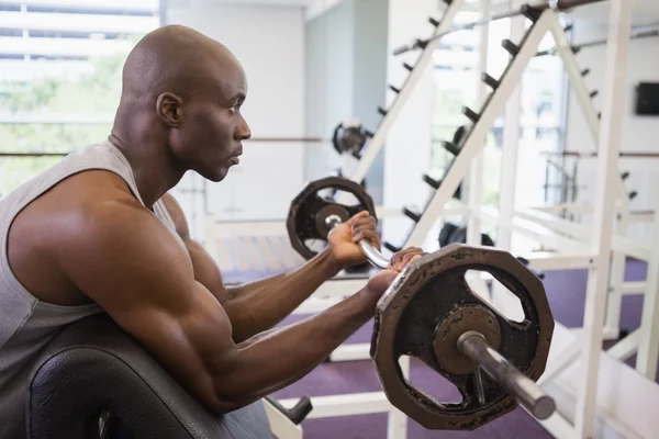 Musclé homme levant haltère dans la salle de gym — Photo