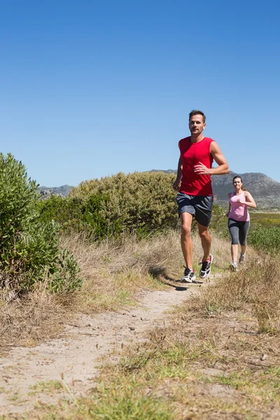 Aktiva par jogging på land terräng — Stockfoto