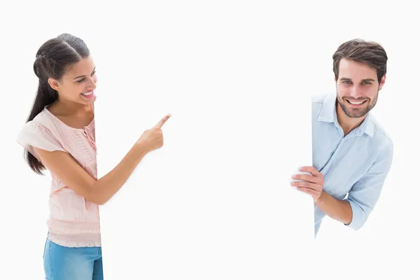 Casal jovem atraente sorrindo e segurando cartaz — Fotografia de Stock