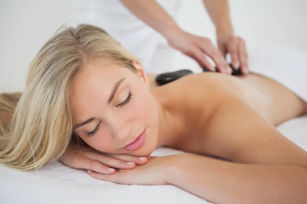 Loira bonita desfrutando de uma massagem de pedra quente — Fotografia de Stock