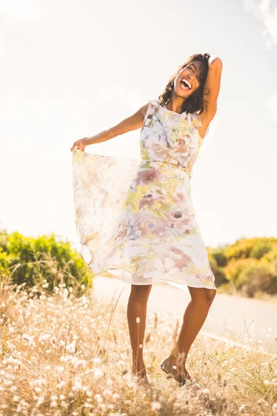 Красивая женщина в цветочном платье улыбается — стоковое фото
