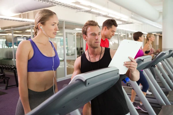 Trainer talking to his client on the treadmill — Stock Photo, Image