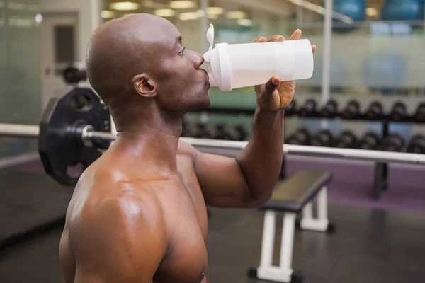 スポーティな若い男がジムでタンパク質を飲む — ストック写真