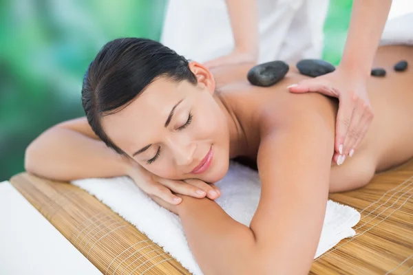 Brunette enjoying hot stone massage — Stock Photo, Image