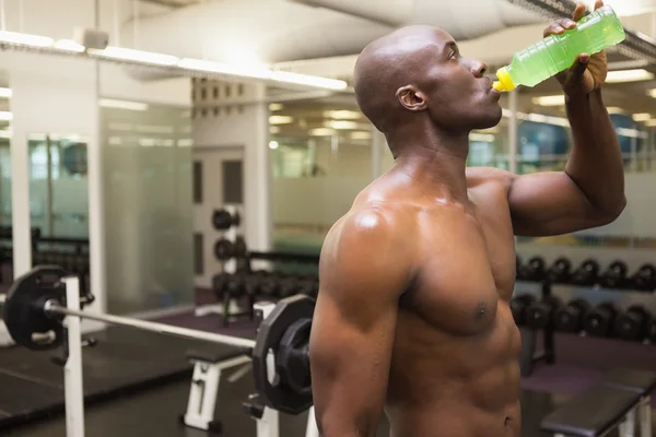 Muscular man drinking energy drink in gym — Stock Photo, Image