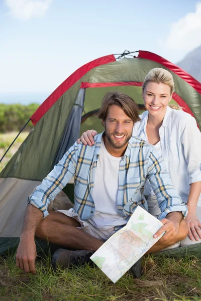 Casal feliz sentado ao lado de sua tenda — Fotografia de Stock