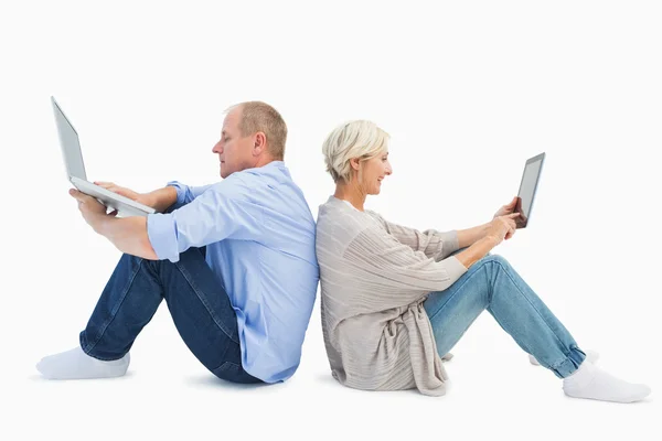 Mature couple using laptop and tablet pc — Stock Photo, Image