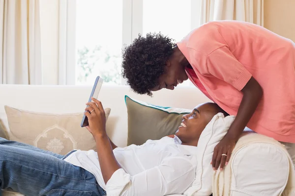 Casal bonito relaxante no sofá com tablet pc — Fotografia de Stock