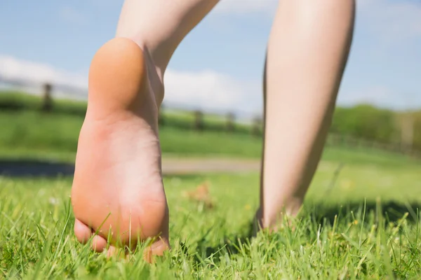 Frauenfüße laufen auf Gras davon — Stockfoto