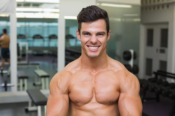 Sorrindo sem camisa muscular homem no ginásio — Fotografia de Stock