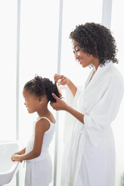 Jolie mère brossant les cheveux de ses filles — Photo