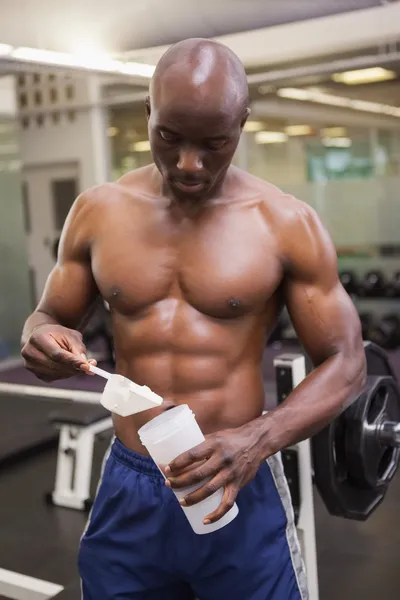 Body builder scooping up protein powder — Stock Photo, Image