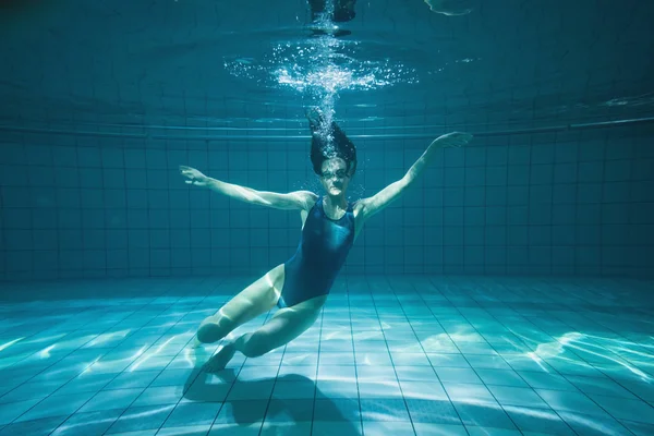 Athletic swimmer smiling at camera underwater — Stock Photo, Image