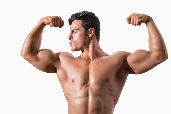 Porträt eines muskulösen jungen Mannes, der die Muskeln spielen lässt — Stockfoto