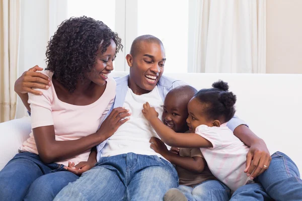 Happy family sitting on the couch together — Stock Photo, Image