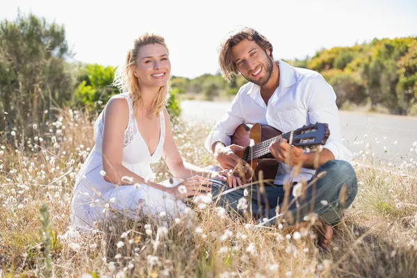 Man serenading girlfriend with guitar — Stock Photo, Image