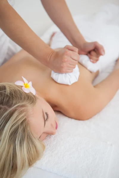 Linda loira desfrutando de uma massagem de compressa de ervas — Fotografia de Stock