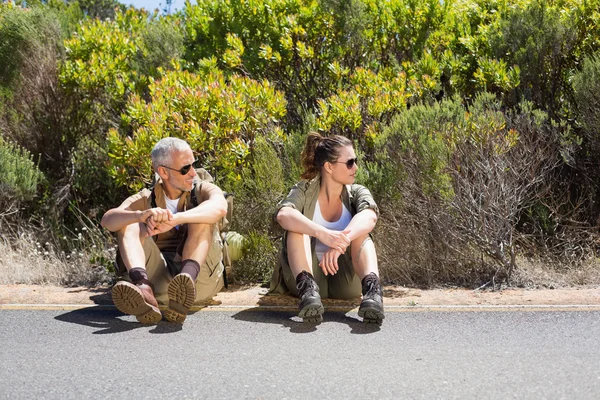 Hitch caminhadas casal sentado no lado da estrada — Fotografia de Stock