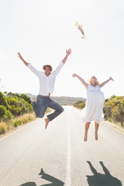 Couple jumping on the road — Stock Photo, Image