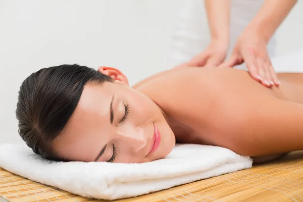 Linda morena desfrutando de uma massagem nas costas — Fotografia de Stock
