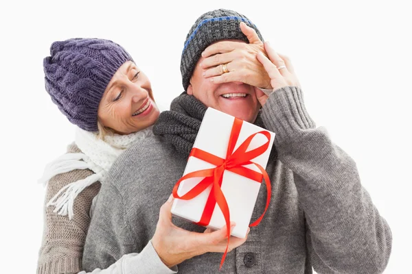 Gelukkig volwassen vrouw verbergen geschenk van partner — Stockfoto