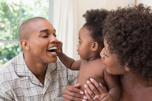 Happy couple on bed with baby daughter — Stock Photo, Image