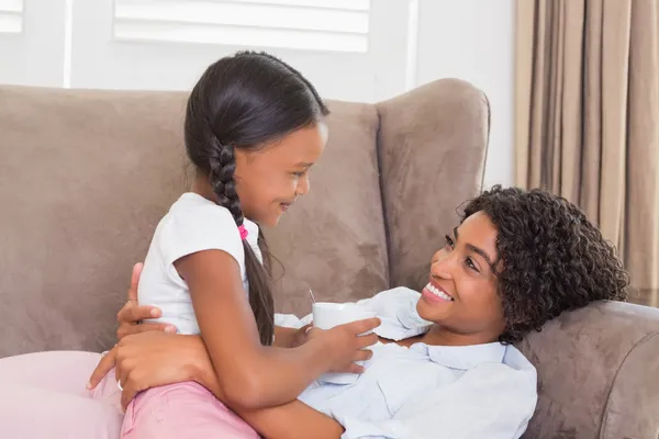 Hübsche Mutter sitzt mit ihrer Tochter auf der Couch — Stockfoto